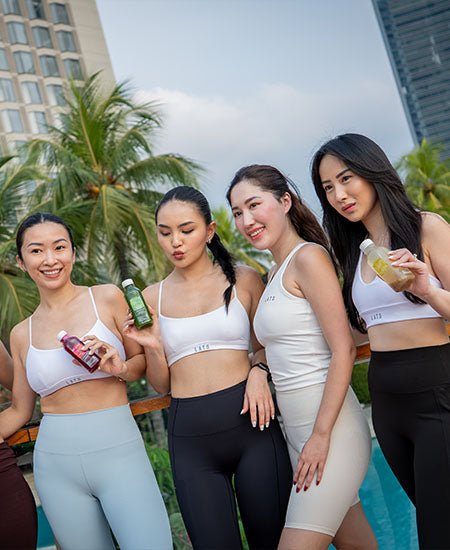 four women in yoga gear holding rejuve juices.