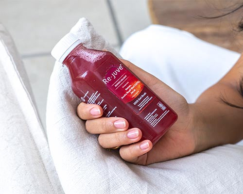Berries delight bottle being held on top of a pillow
