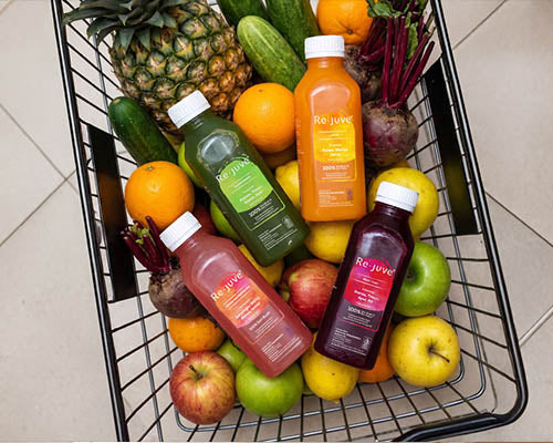 Shopping basket filled with fruits and bottles of Re.juve.